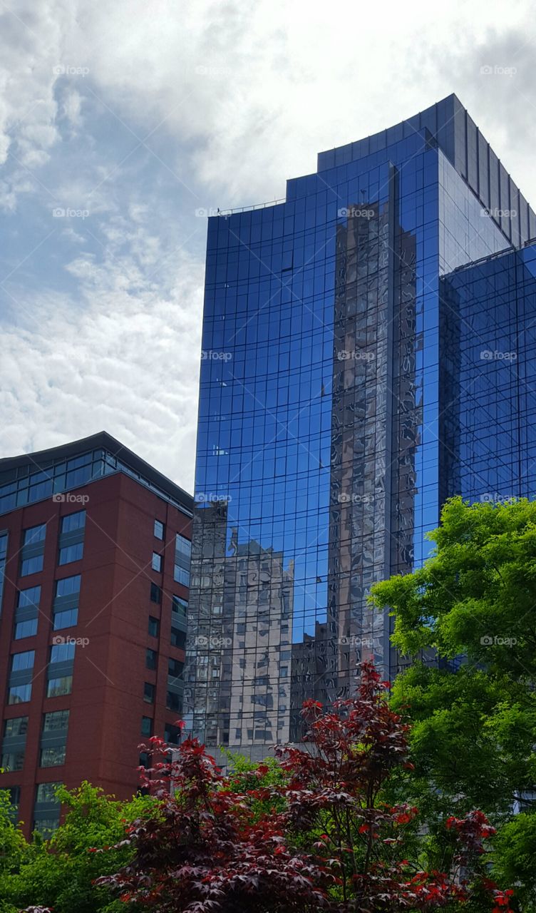 A cityscape is reflected in a building facade giving a view within a view.