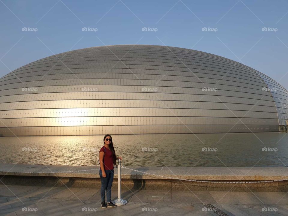 Young traveler in circular building in Beijing China at sunset