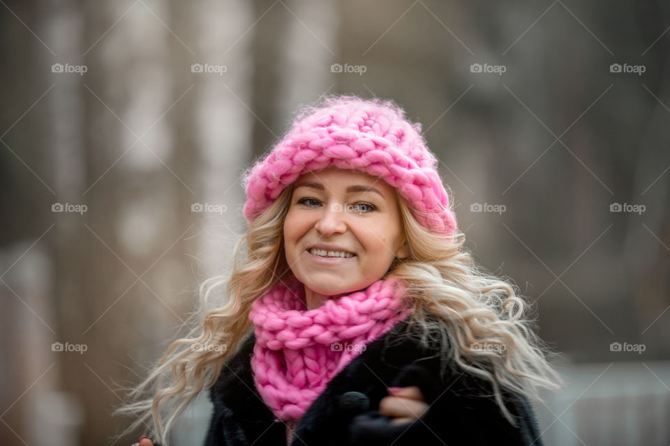 Outdoor Portrait of blonde woman in pink crochet accessories 