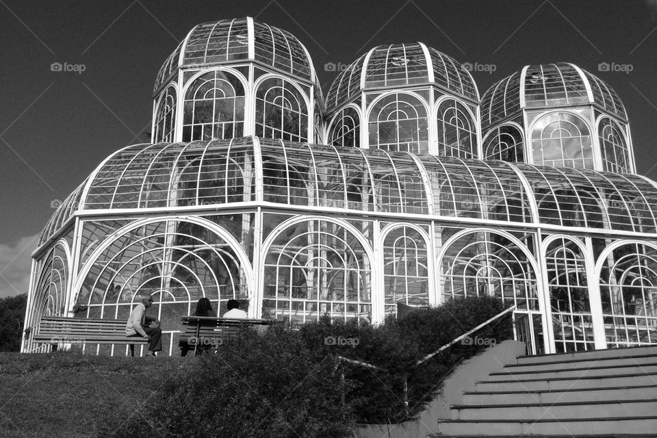 Botanical Garden of Curitiba, in Parana, Brazil seen from below in a very clear day. Its curved metallic white structure closed with glasses gives the false impression of a frail construction.