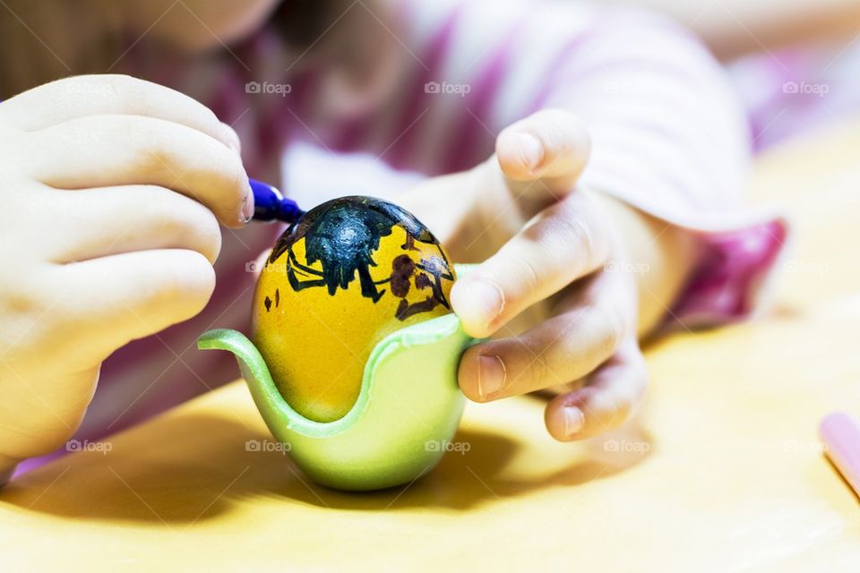 Children painting eggs for Easter