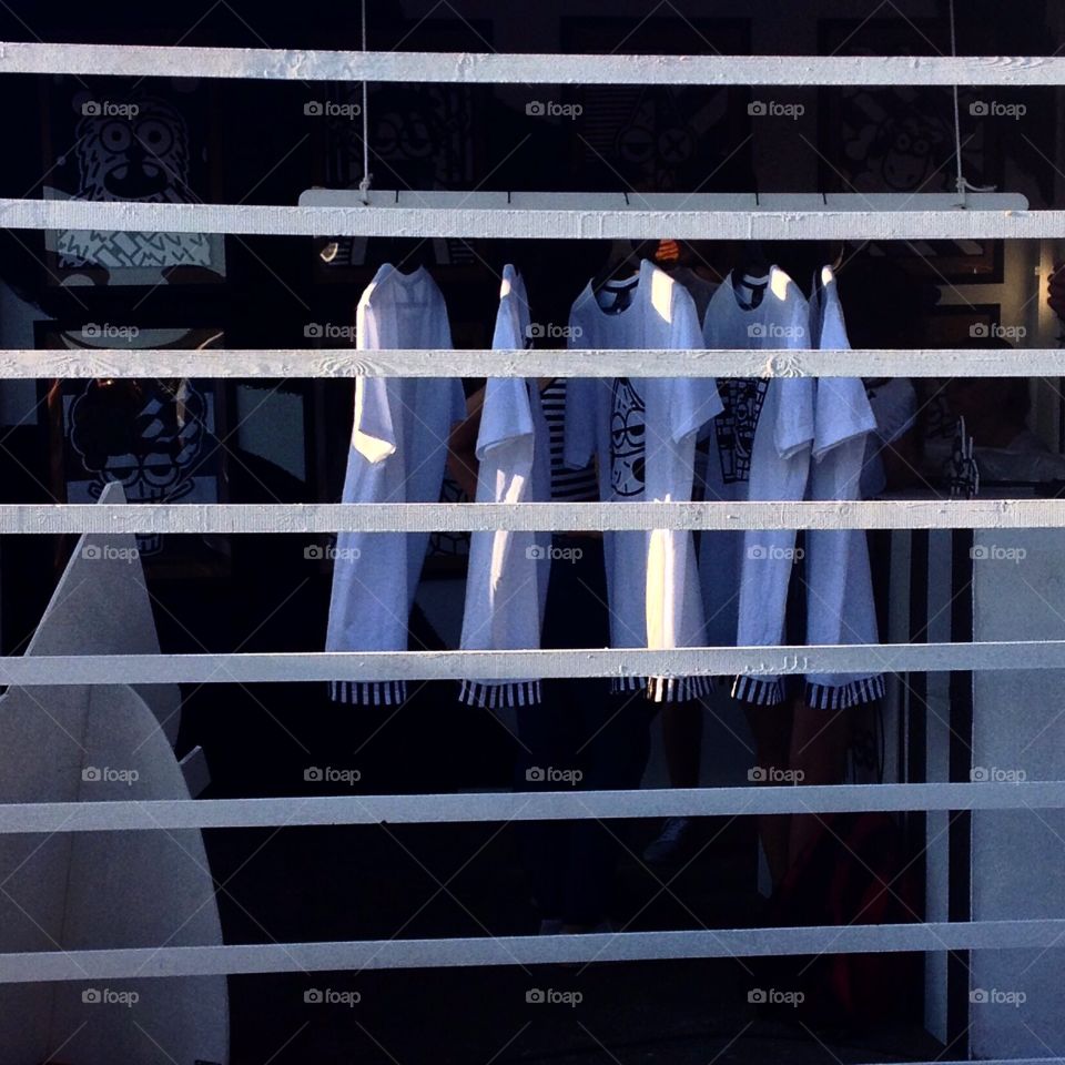 T-shirts at the fair . T-shirts in the pavilion at the fair. Wall with horizontal slats. T-shorts with vertical stripes.