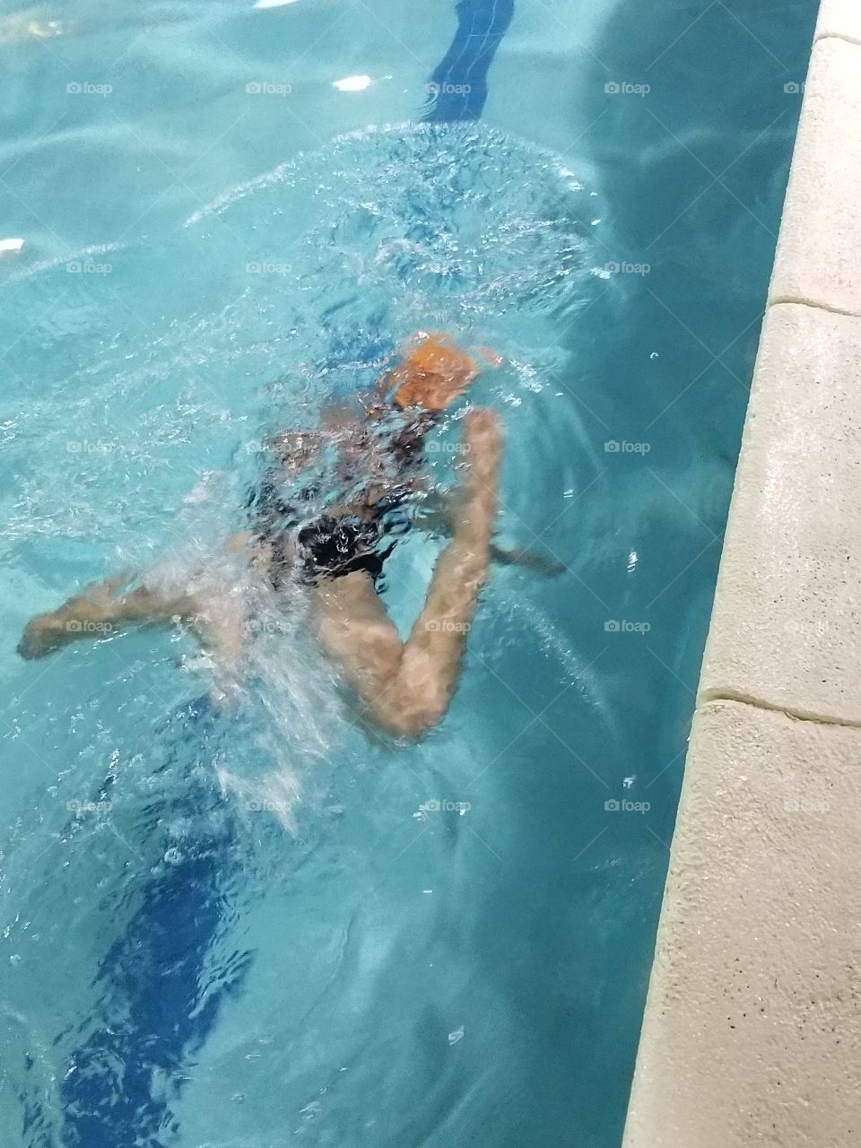 child swimming in a pool