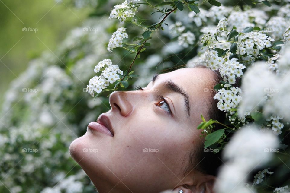 Young woman in a see of white flowers