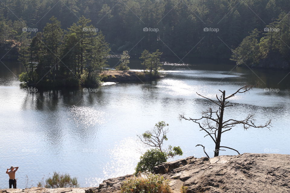 Beautiful scenery of the lake and woods around seen from top of the rocky hill