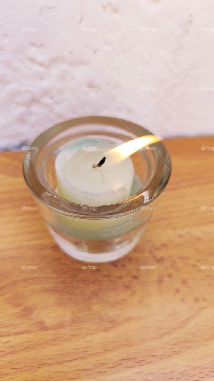 A burning candle on a table