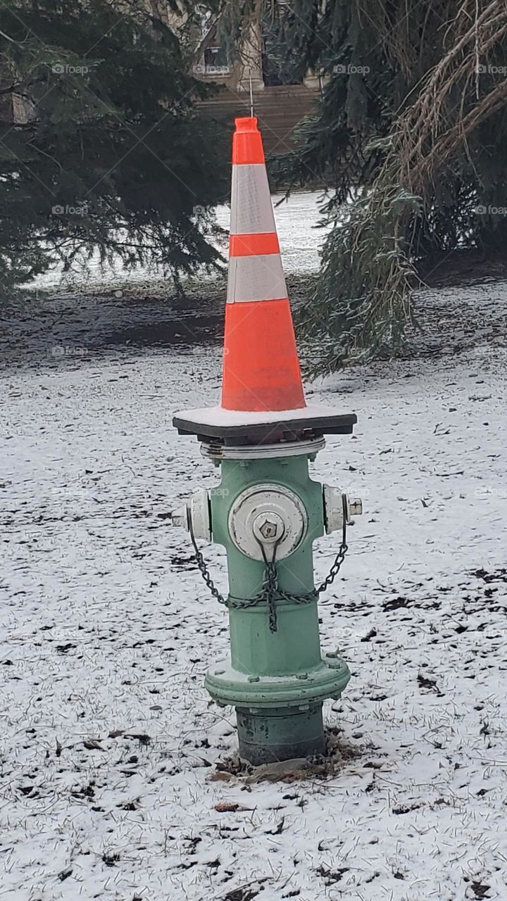 Fire hydrant with orange traffic cone on top