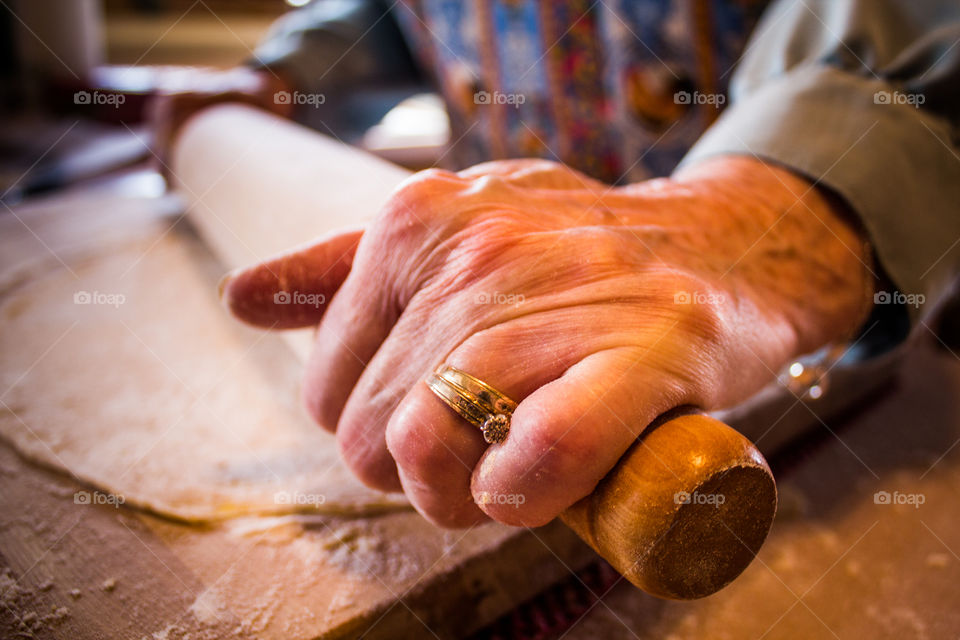 Close-up of a person rolling dough with rolling pin