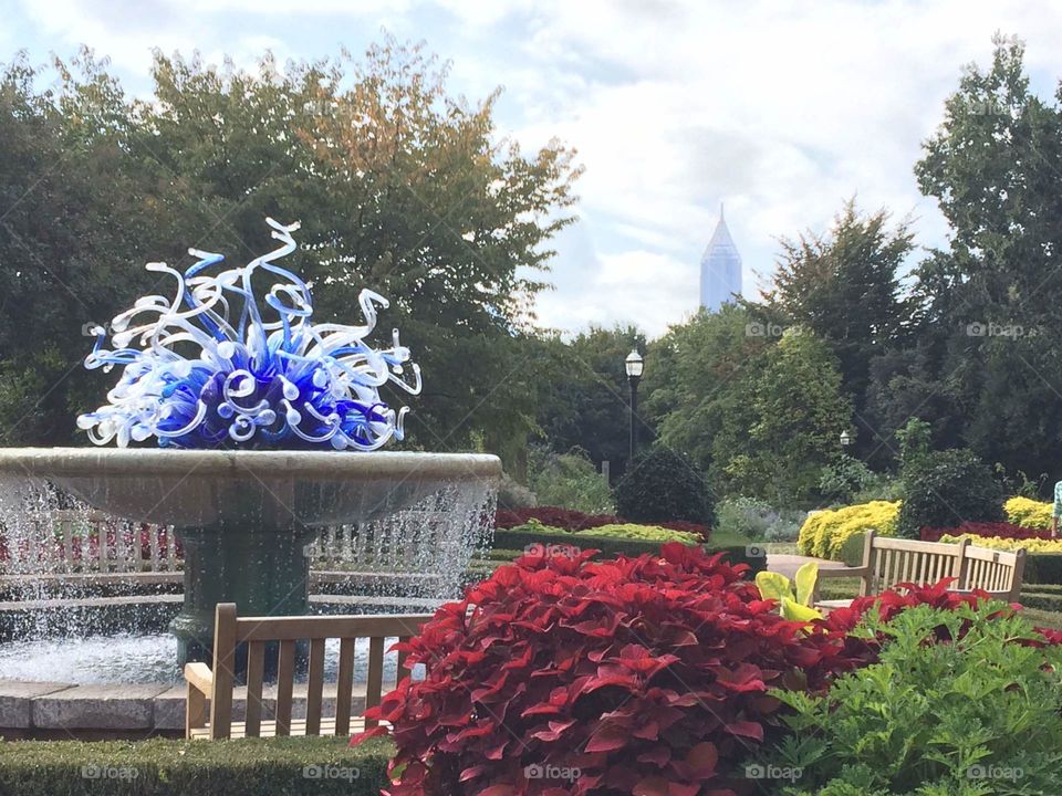 Atlanta skyline with Chihuly glass sculpture, fountain and plants at the Botanical garden