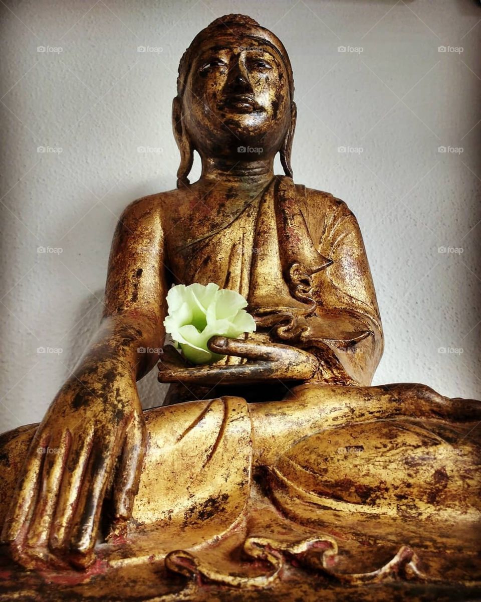 17th century buddha statue with flower