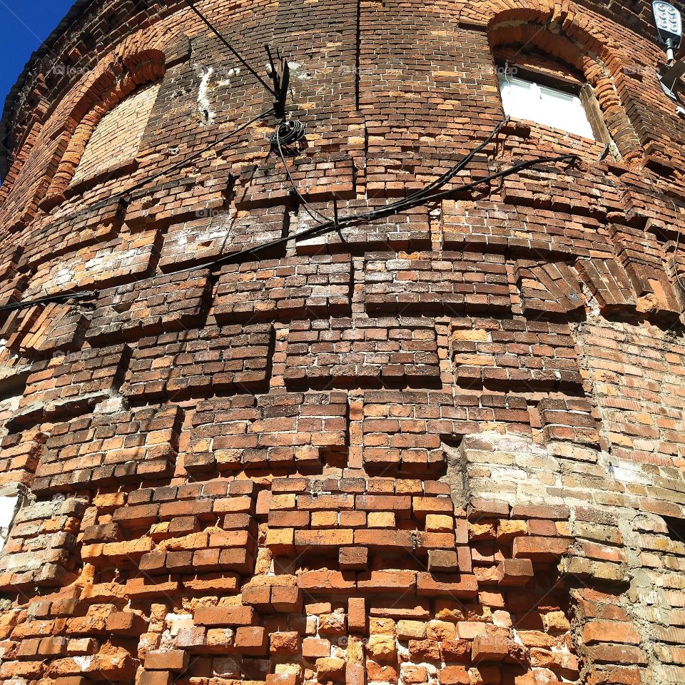 An old brick building with windows that look like eyes
