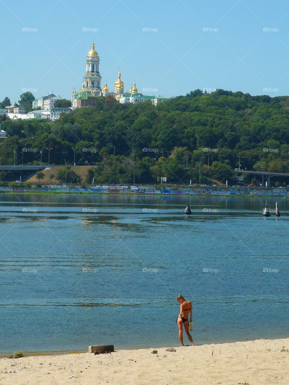 girl sunbathing on the beach on the Dnieper river in the city of Kiev, Ukraine