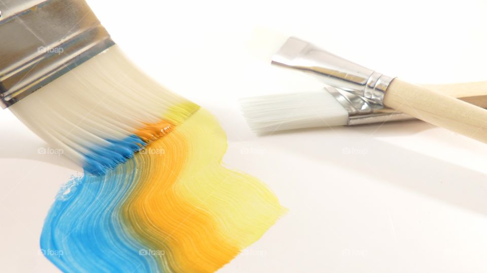 Brush with colorful paint isolated over white background