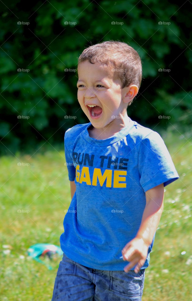 Running through the sprinkler in the backyard 