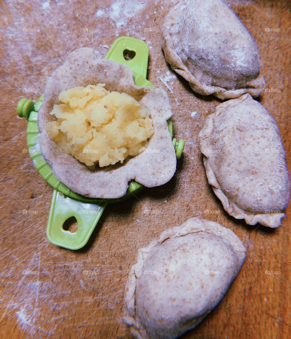 Making potato dumplings at wooden desk 