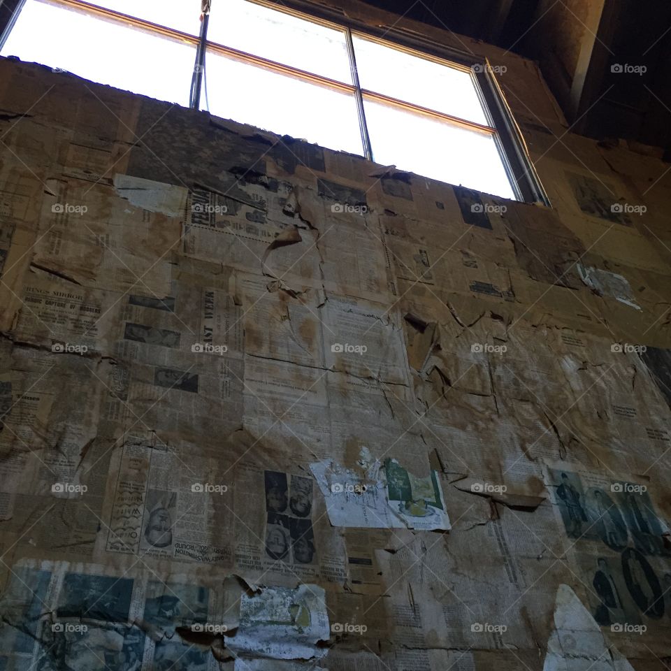 Newspaper editor wall in old building with window.