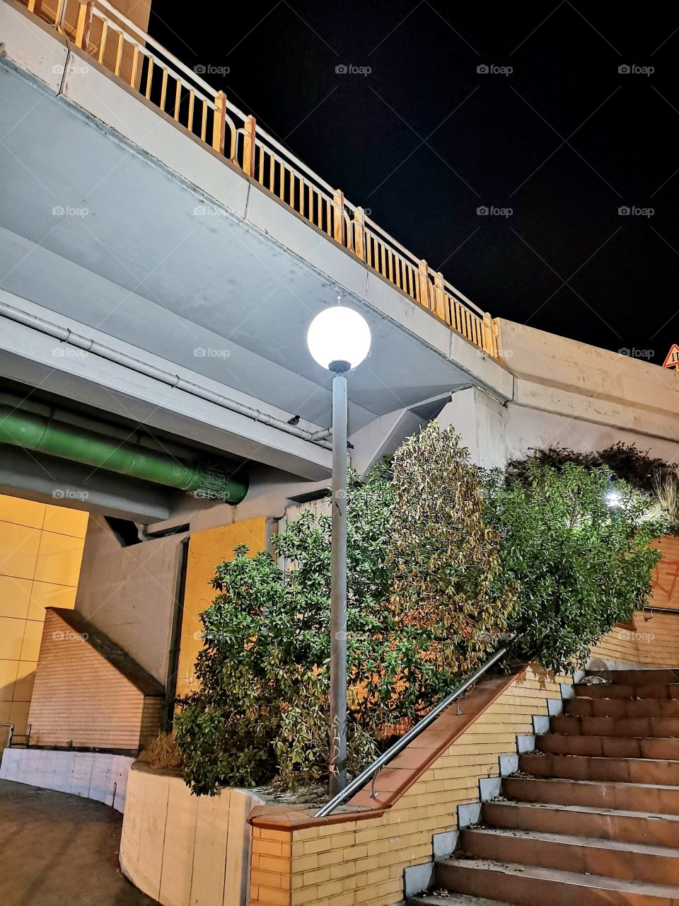 Watching illuminated pole on the urban promenade