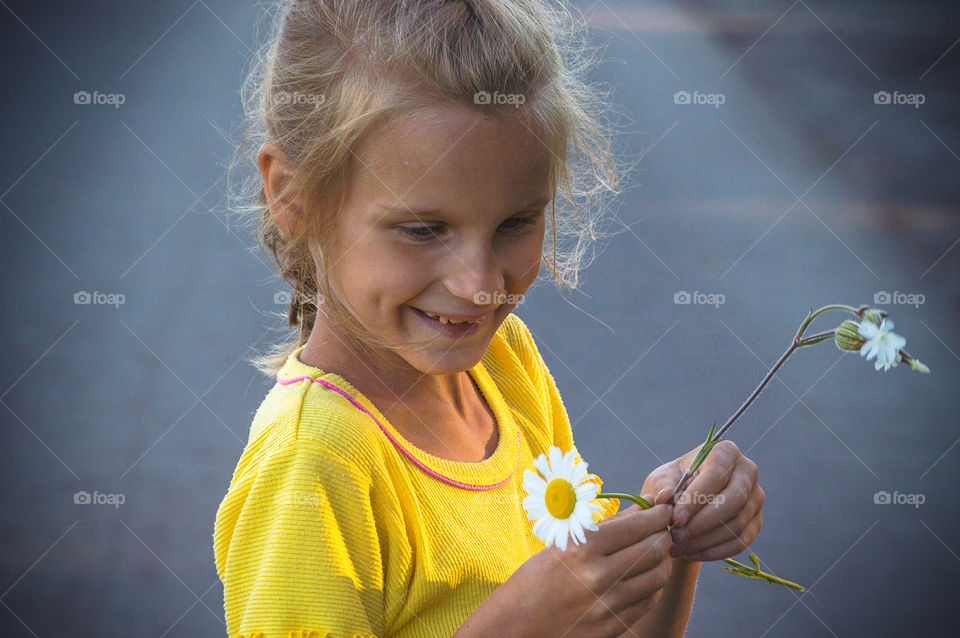 Little girl with a daisy