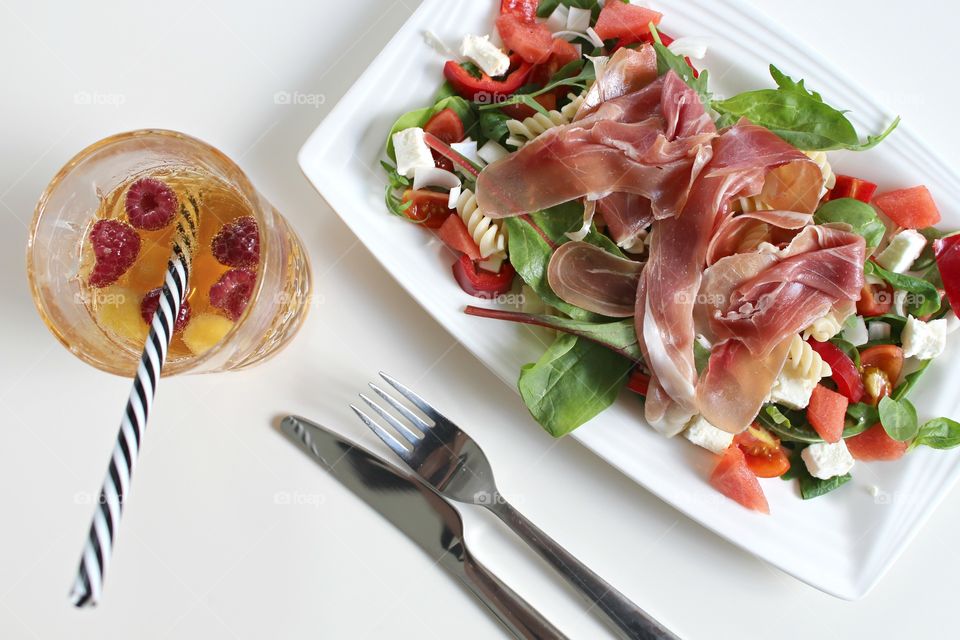 Salad with raspberry juice in drinking glass