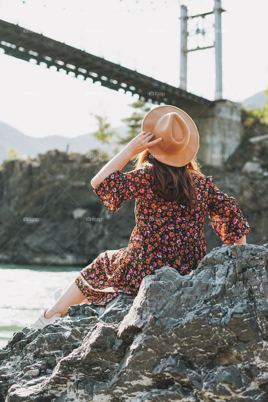 Young woman in dress and felt hat on Horochowski bridge on river