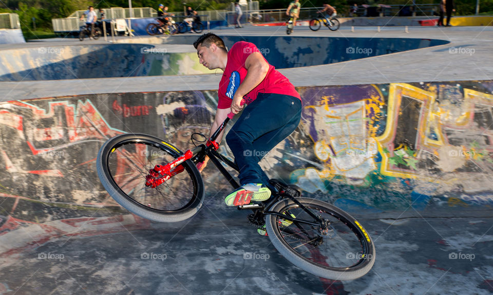 BMX bike rider flying off a concrete wall in an urban park in Bucharest