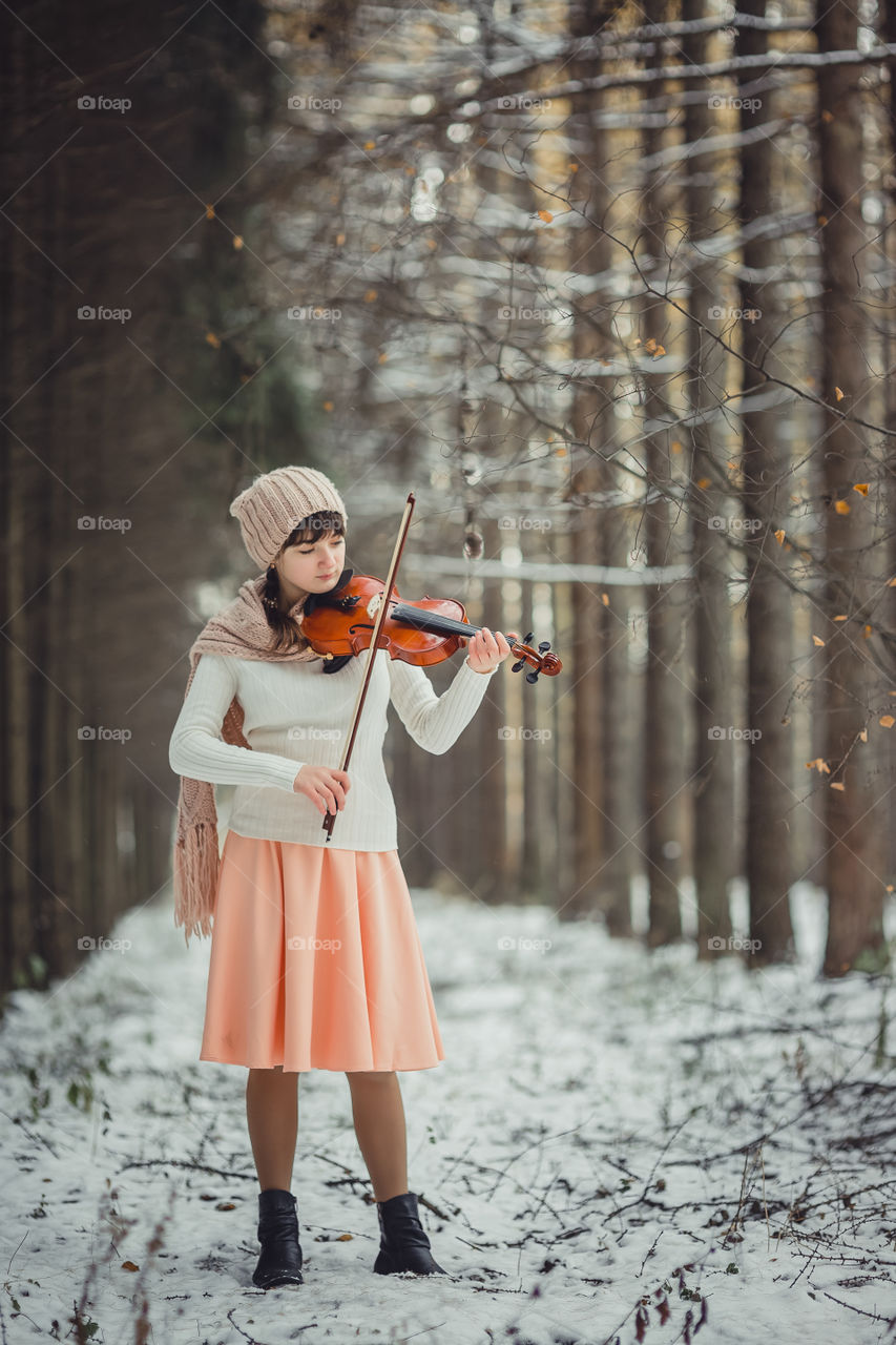 Teenage girl portrait with violin in winter park