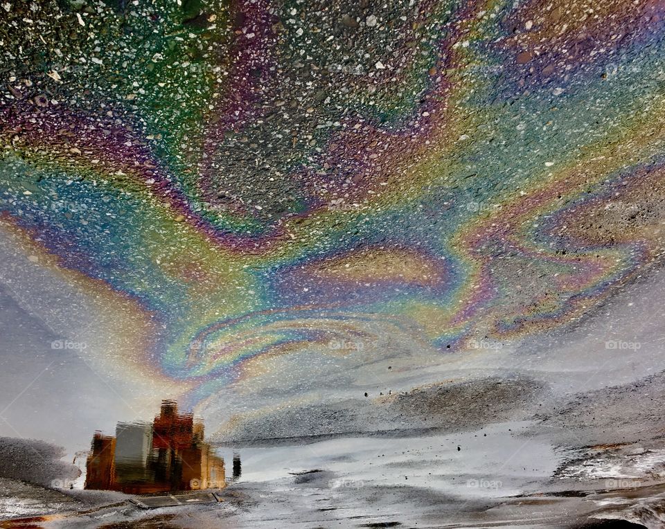 Abstract photography.
Oil on water as aurora borealis, pavement as starry sky, yellow  truck reflection as building and dry ice as snowy land. Photo is rotate 180.