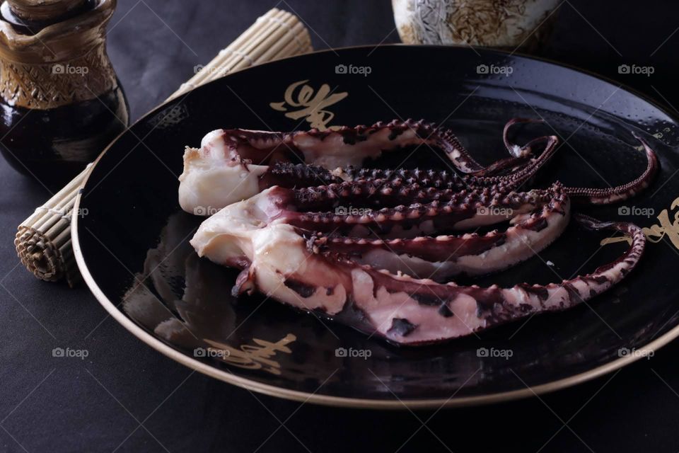 squid served on a dark round plate
