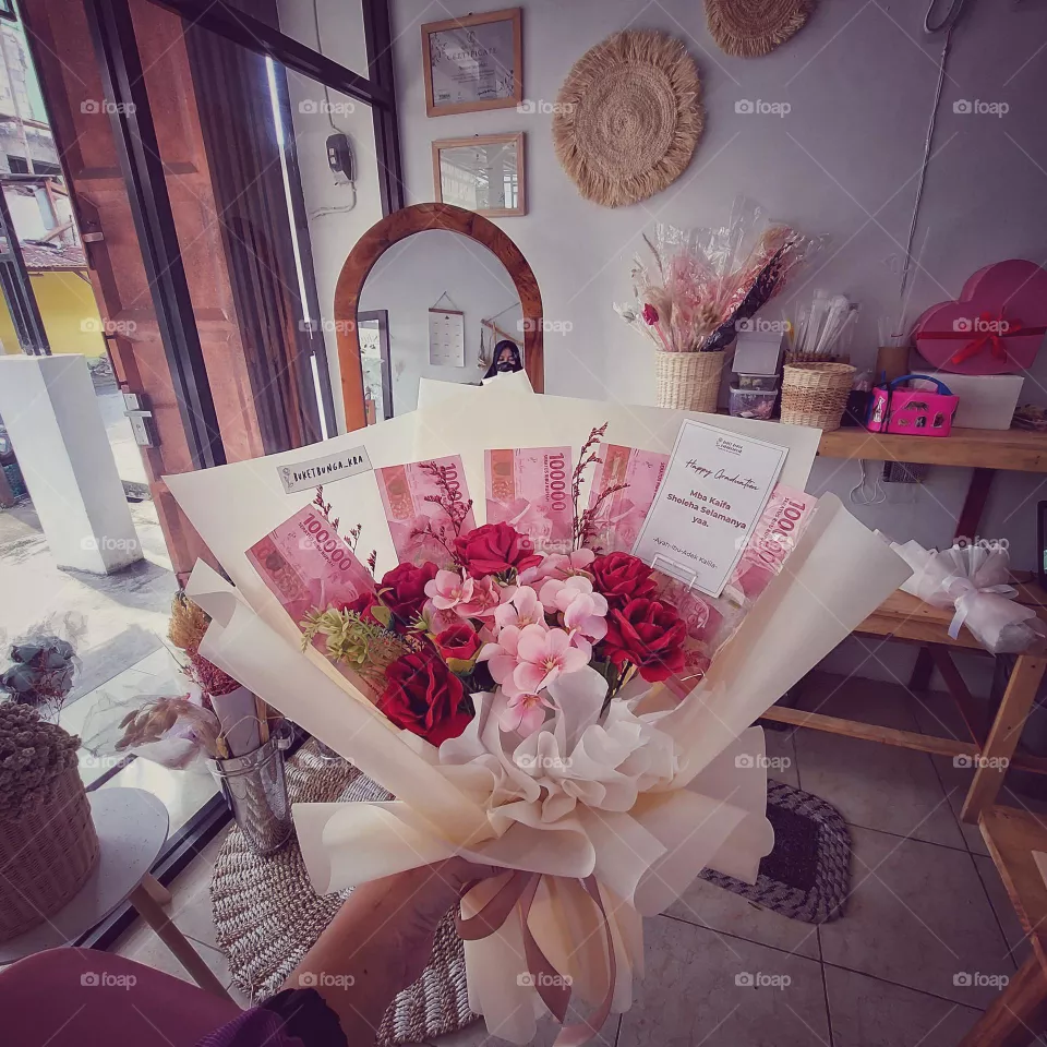 Flowers and money bouquet. The official currency of Indonesia is Rupiah which is Issued and controlled by the Bank of Indonesia.
