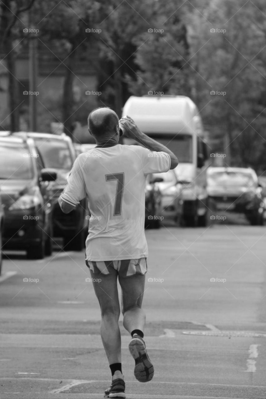 Rear view of a man jogging through the city