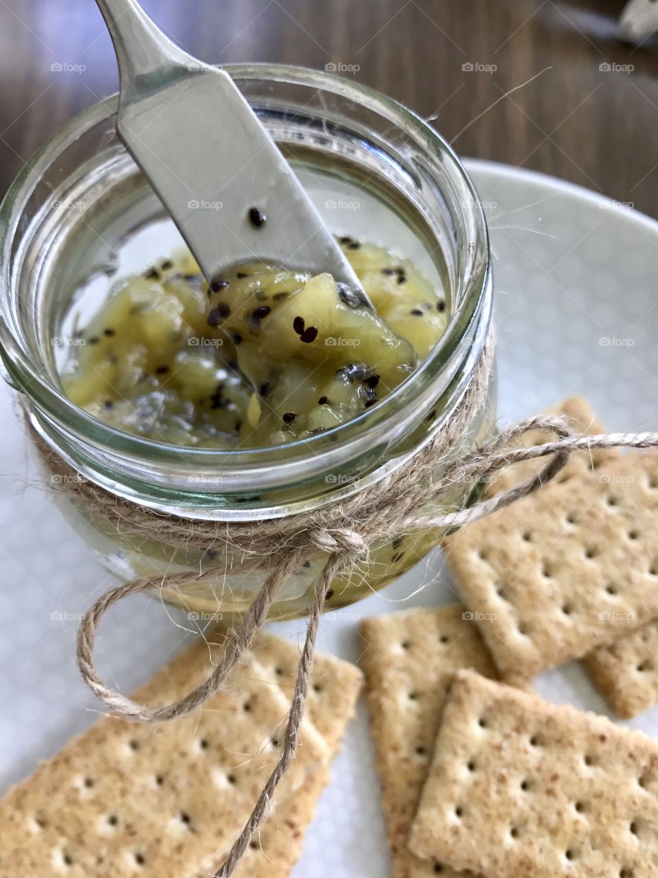 Homemade Kiwi jam and crackers on a plate 