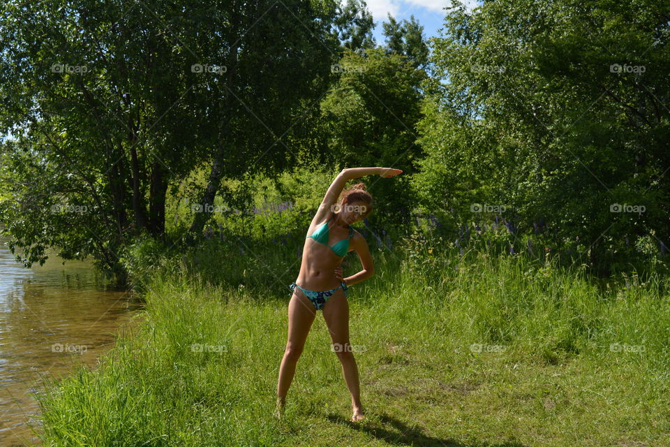 brunette girl in swimsuit itraining yoga outdoor, summer time, green beautiful landscape