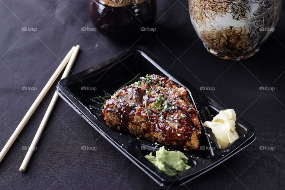 Japanese food served on a square black plate