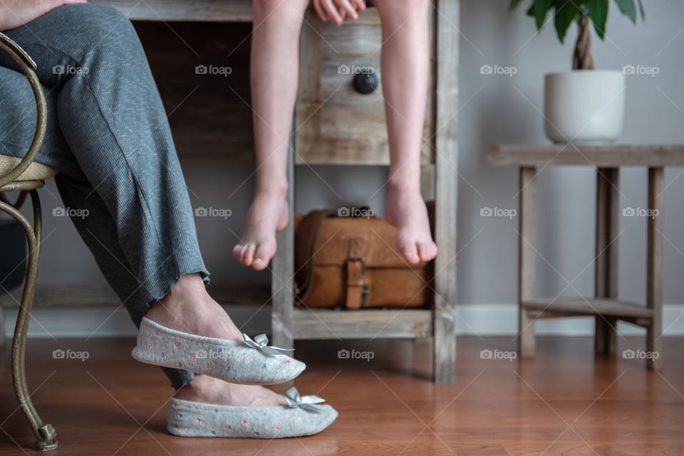Woman wearing slippers and sitting at home with child