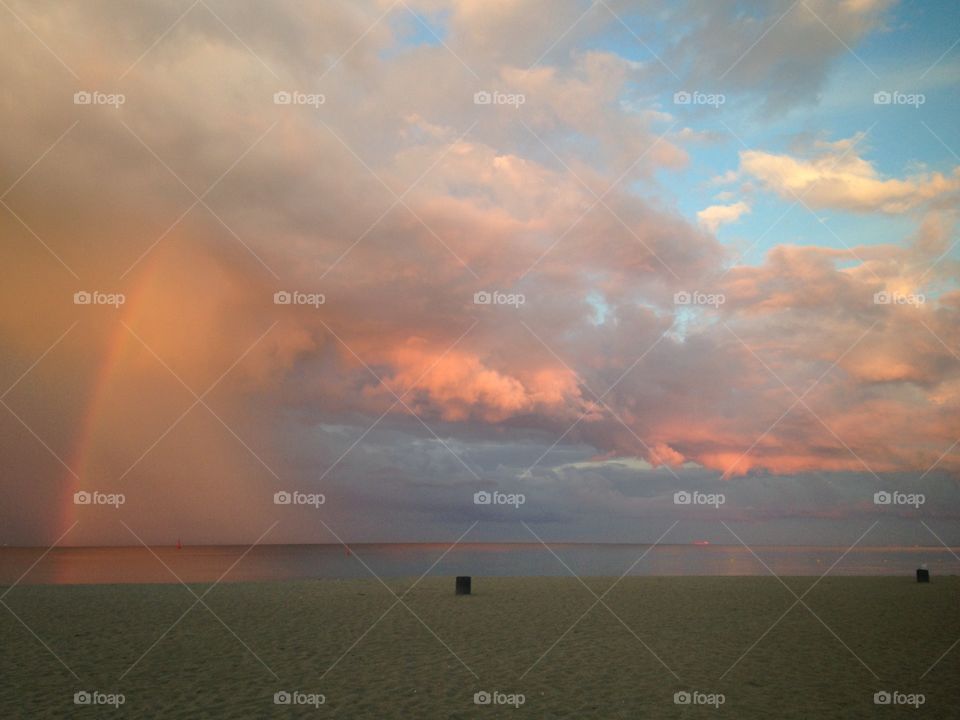 The rainbow in the sunset sky over the Baltic Sea in Poland 