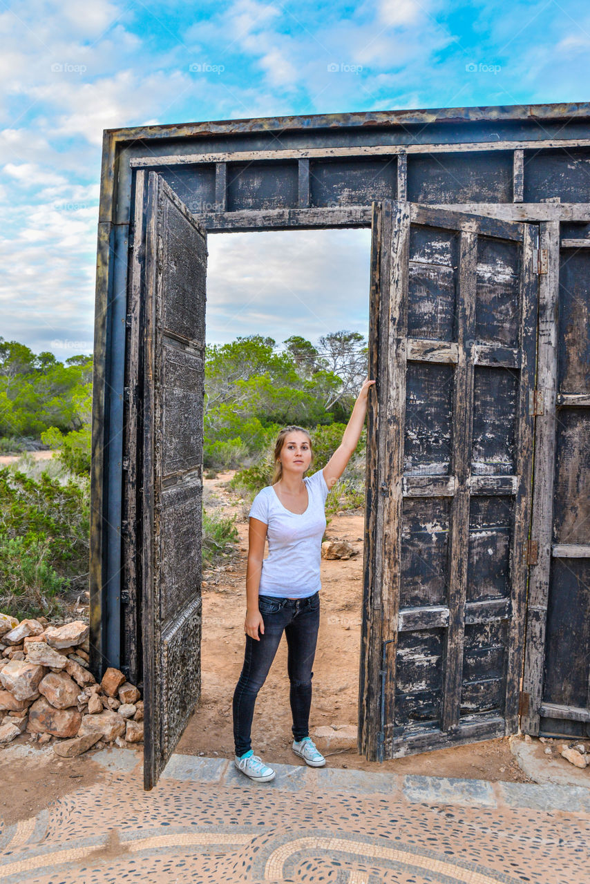 Woman standing near ancient door