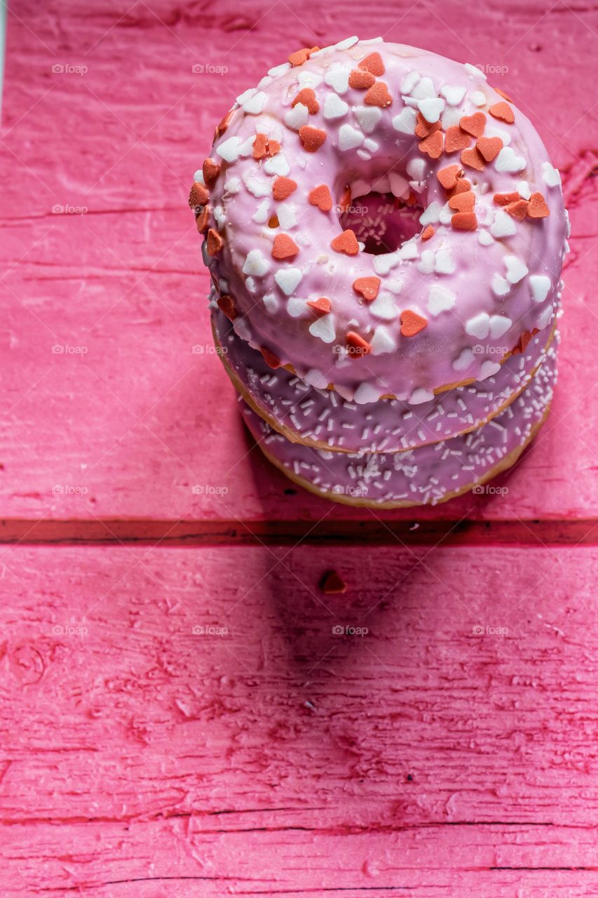 Stack of pink donuts on a pink table