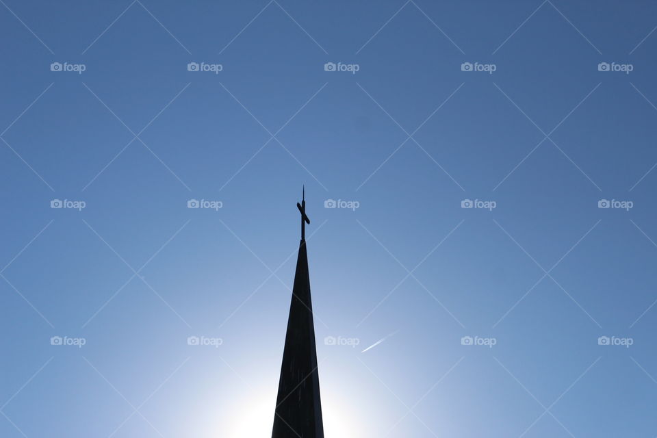 Silhouette of a steeple against a setting sun