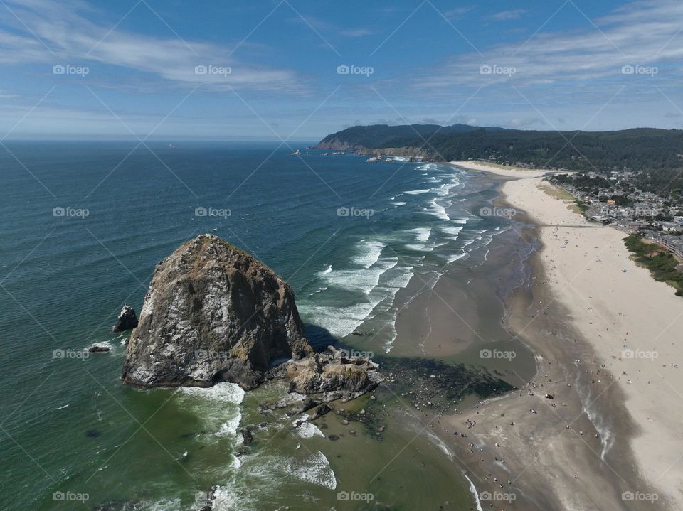 Haystack Rock standing tall amidst the serene beauty of Cannon Beach, where tide pools meet the endless horizon