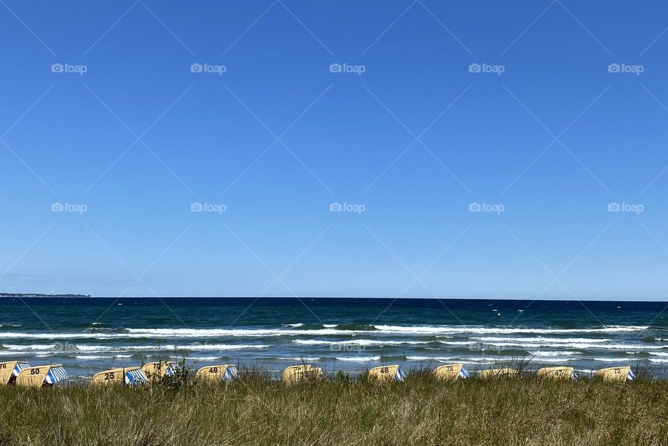 Maritim beach gras and any beach chairs, waves and deep blue sky 