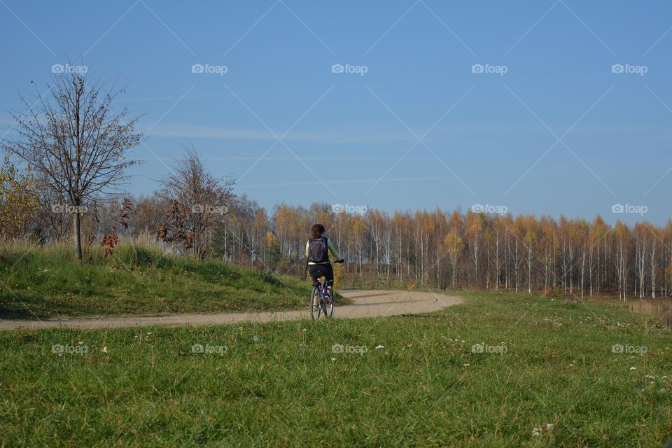 woman riding bike beautiful nature landscape autumn nature blue sky background