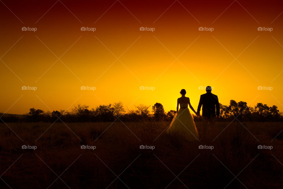 Silhouette image of a couple in the holding hands during an African Sunset. Image from South Africa
