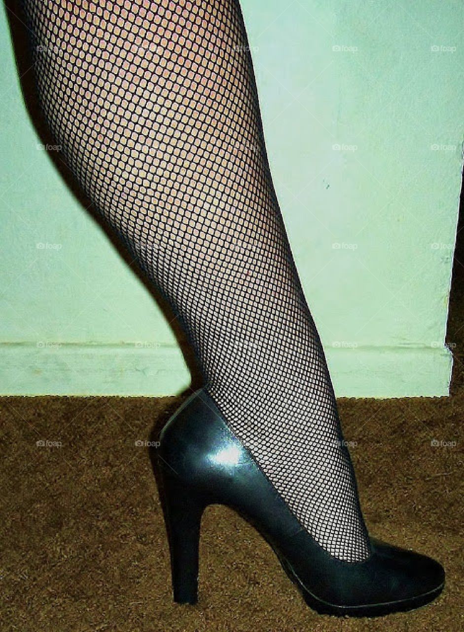 Sexy leg in fishnets and high heels.
