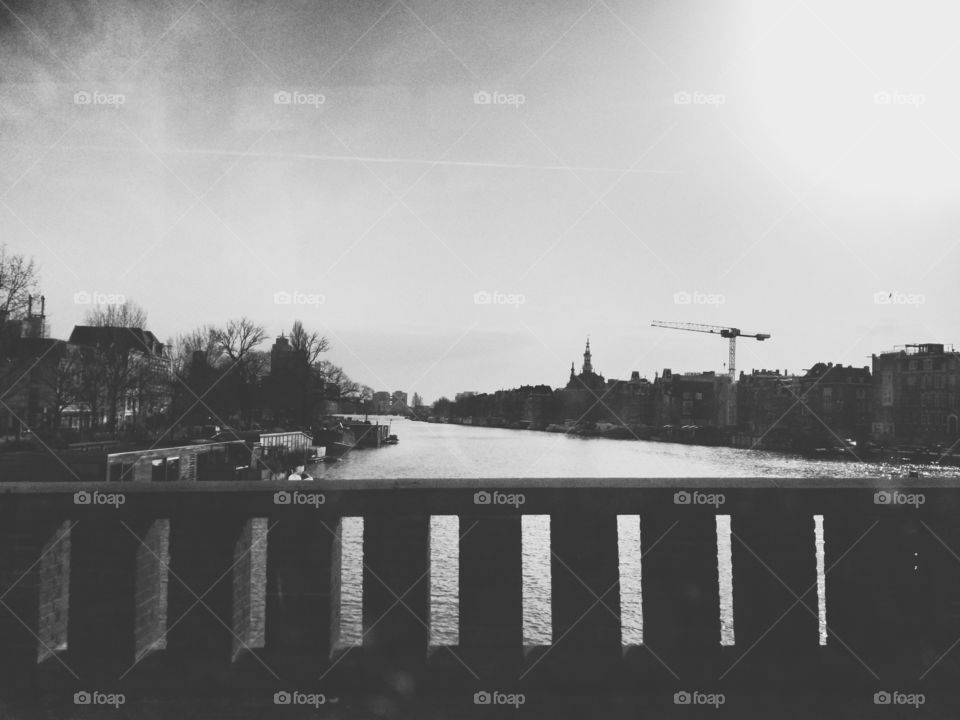 River Amstel, Amsterdam, through a car window in black and white with a crane in the background
