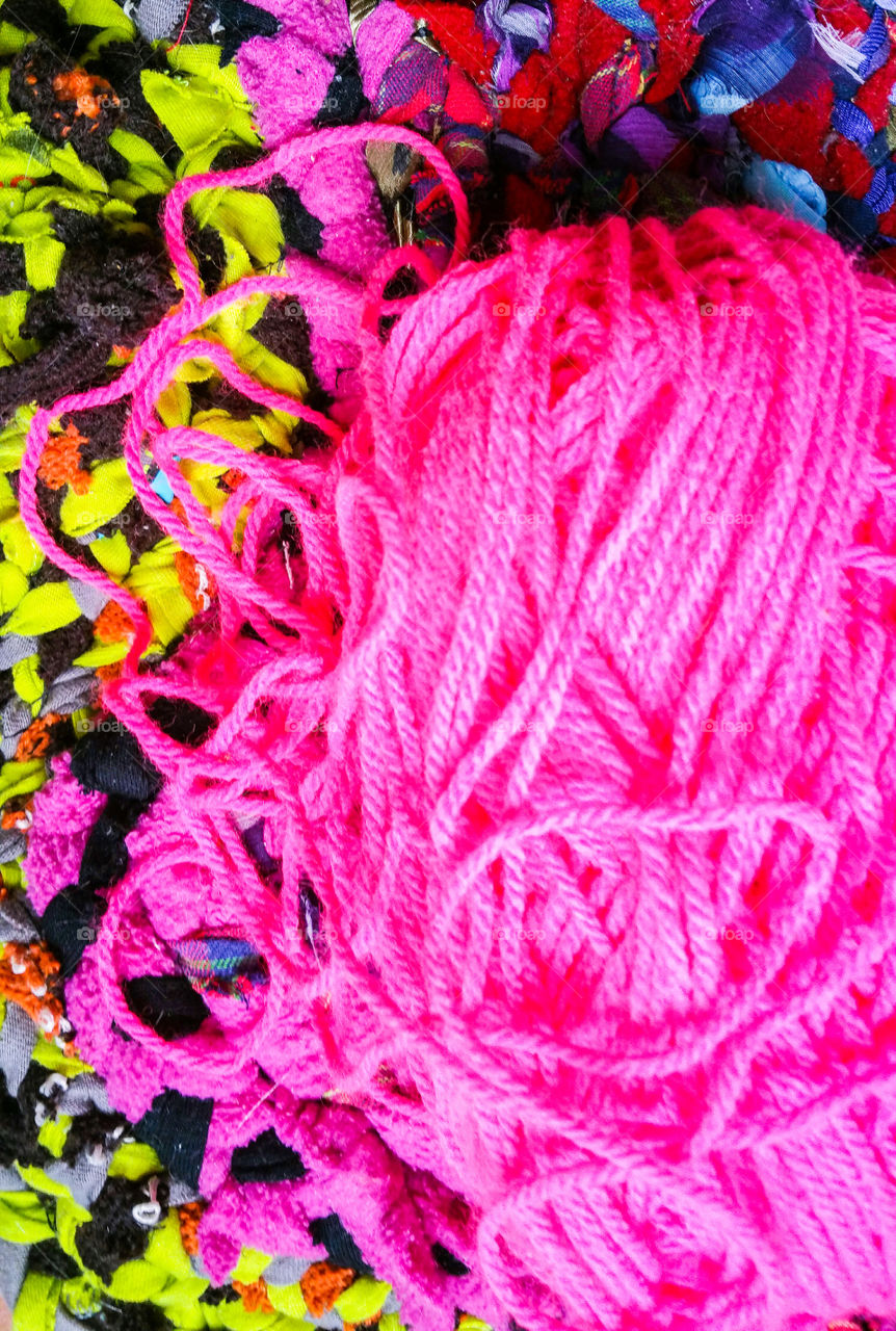 Pink yarn and a rag rug