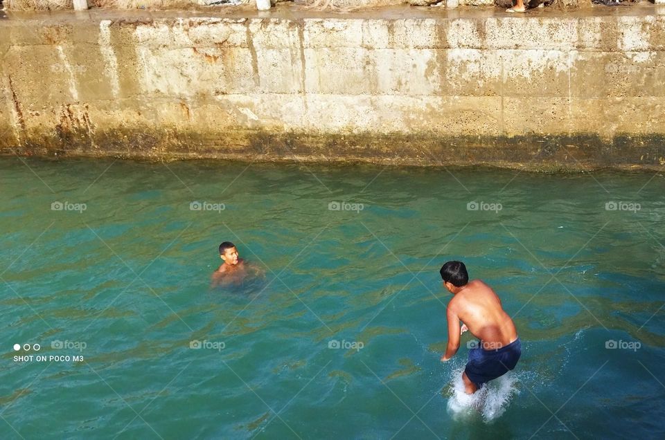 splendid jump into water at essaouira Harbour in Morocco.