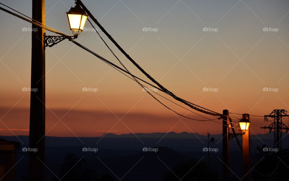 two street lamps in the sunset