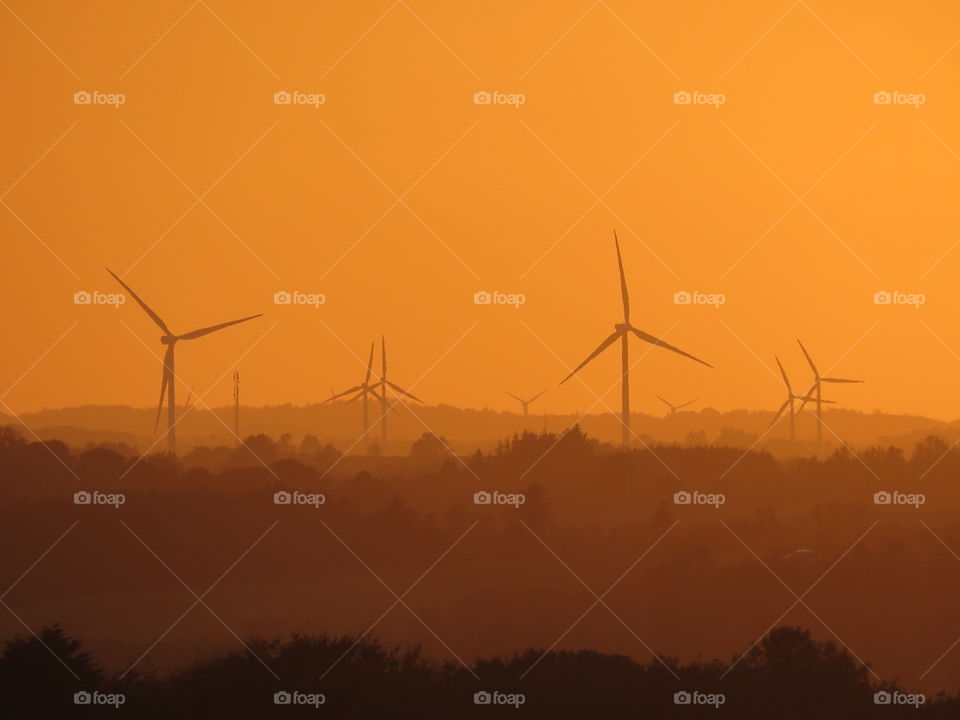 A local area with windmills in the sunset.