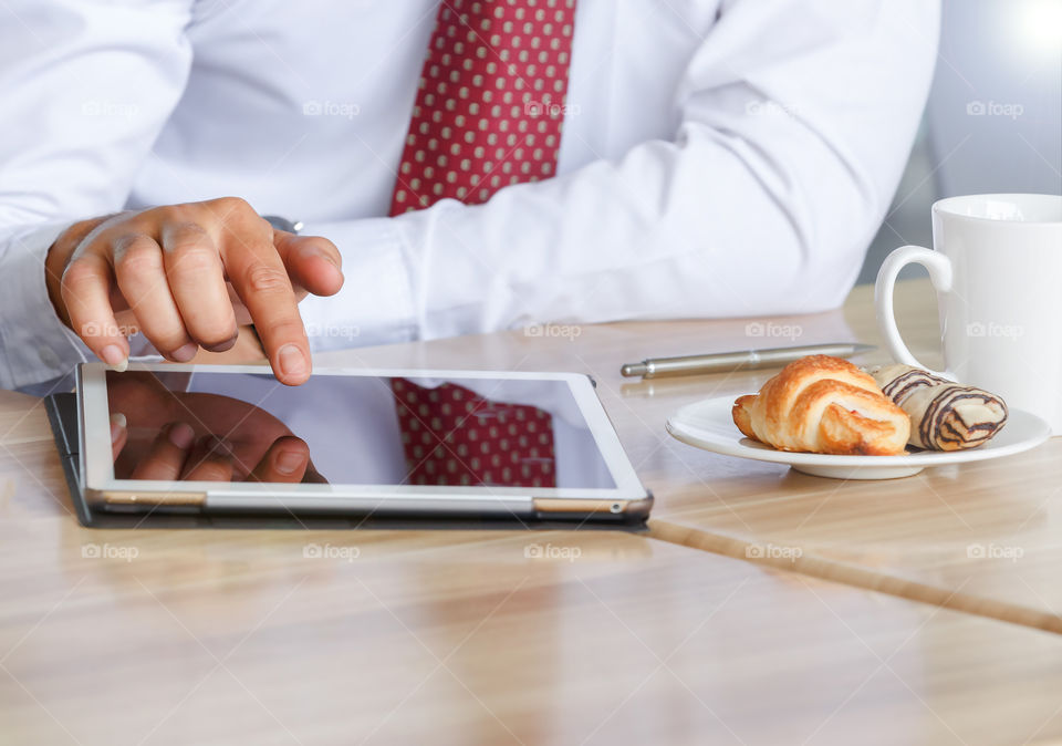 businessman using tablet at breakfast 