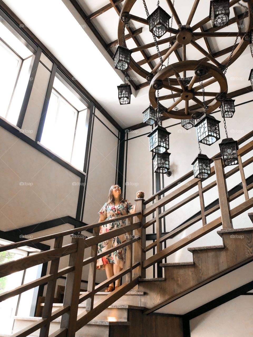 Circle wooden chandelier in hotel and stairs woman 